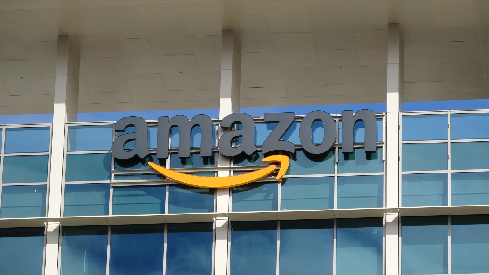 Close-up of sign with logo on facade of the regional headquarters of ecommerce company Amazon