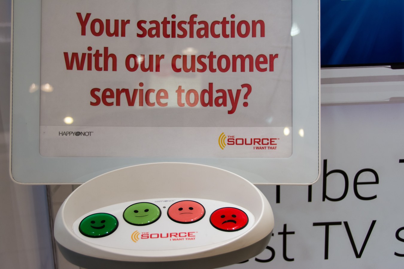 Measuring customer satisfaction in store: Colorful buttons with smiley faces, on a white plastic device that enables customers to give feedback about their level of customer service satisfaction