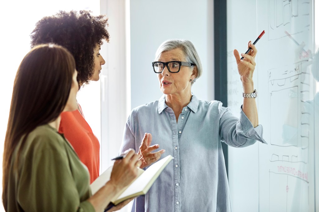 Business woman describing strategies to two colleagues.