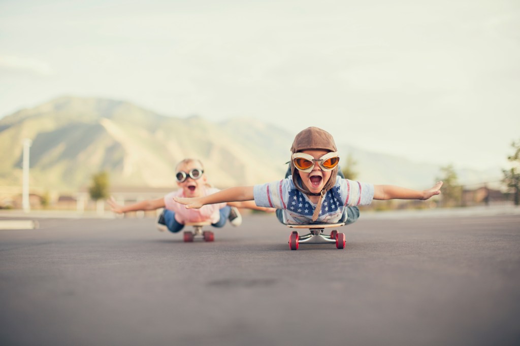 Young Boy and Girl Imagine Flying On Skateboard
