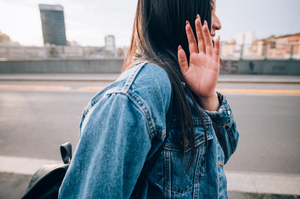 Woman in denim jacket trying to avoid being photographed