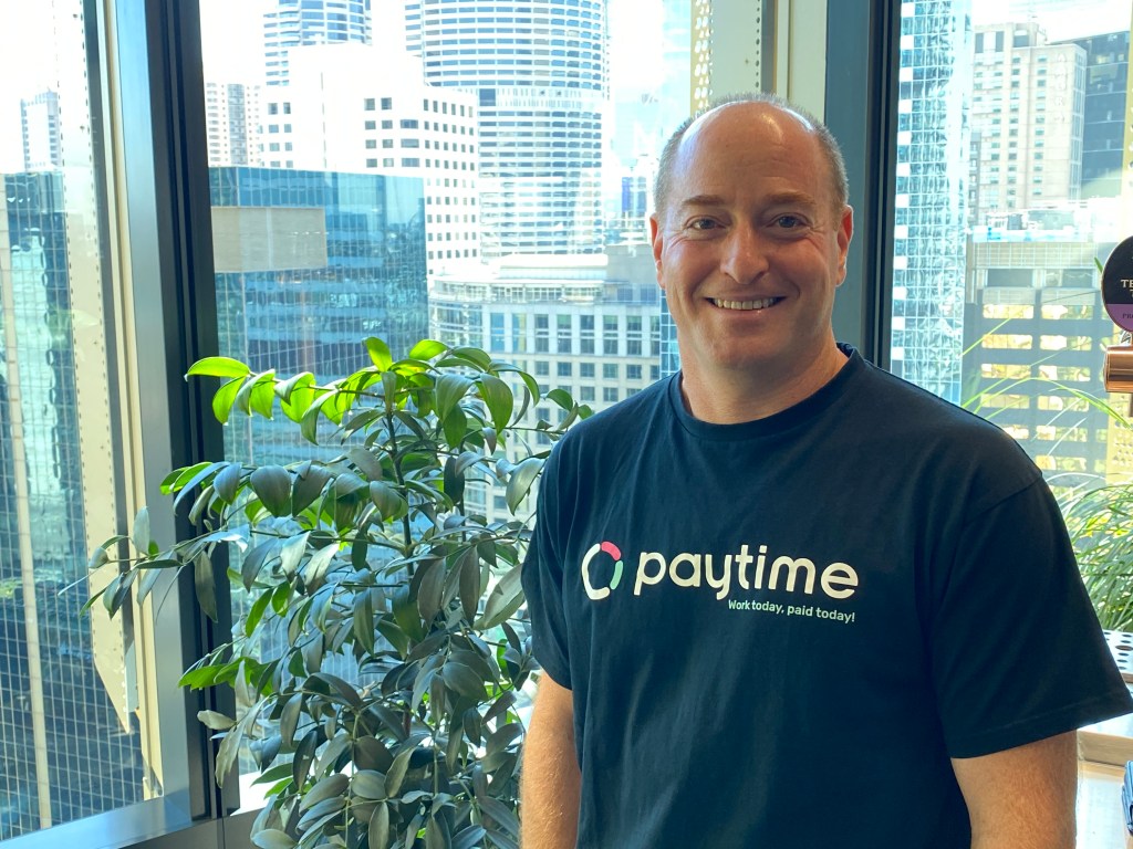 Paytime CEO Steven Furman in front of windows showing CBD