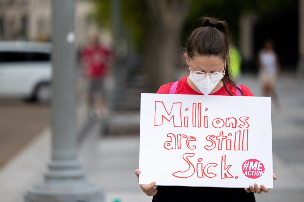 Sick person holding sign at a protest.