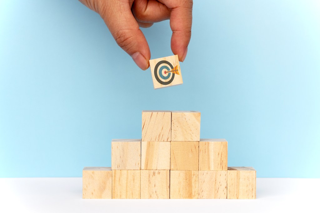 blocks stacked with top block showing a target with an arrow in the centre