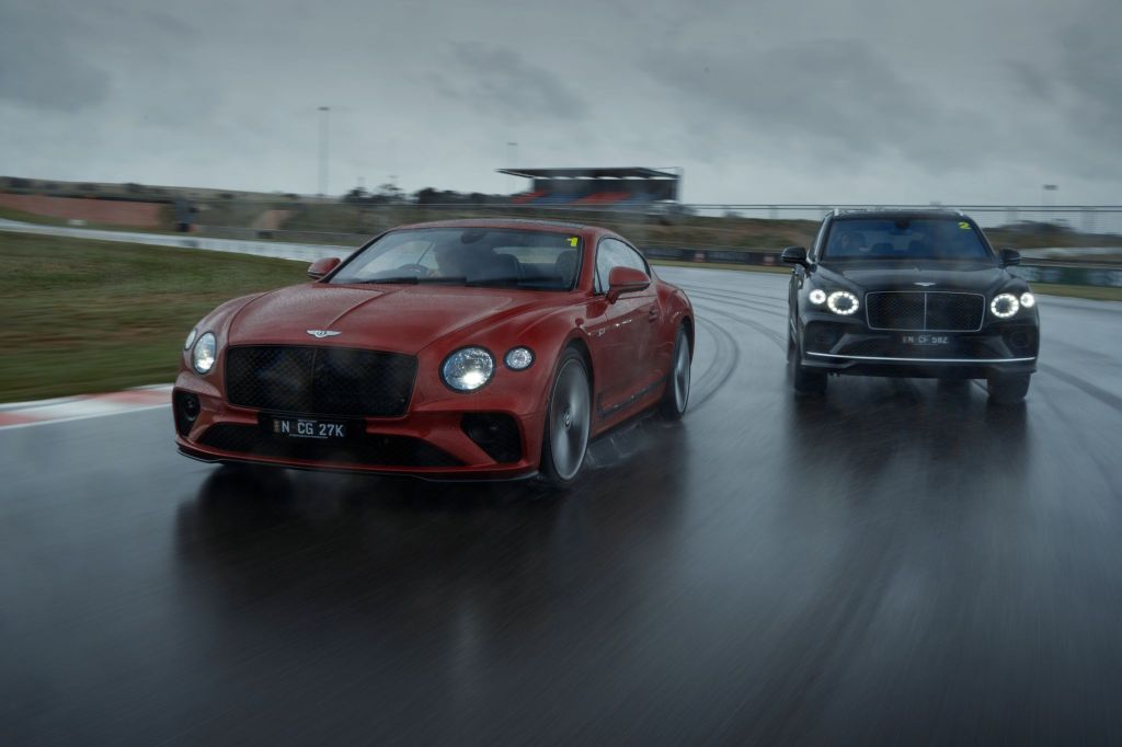 The red Continental GT Speed is pictured on the left. The black Bentayga Speed is pictured on the right. They are driving on Adelaide's The Bend track.