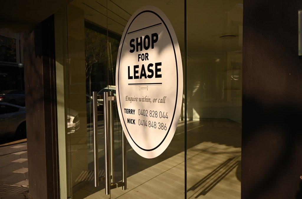 Shop for lease sign in window of empty store