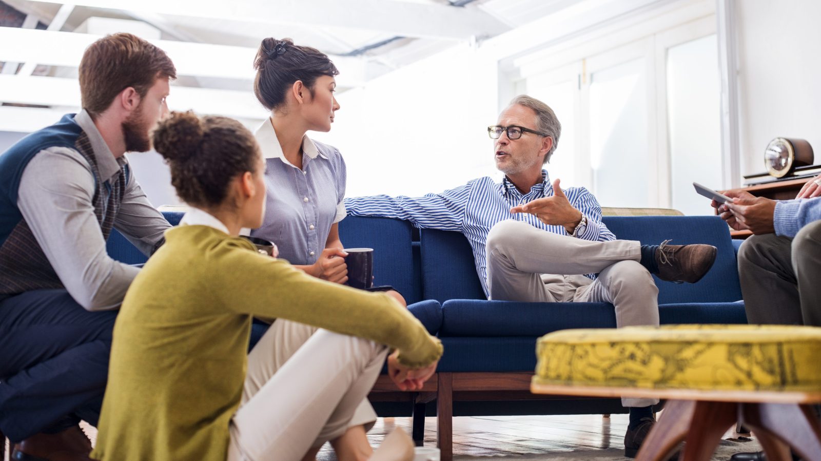 Mature businessman discussing with young colleagues in creative office