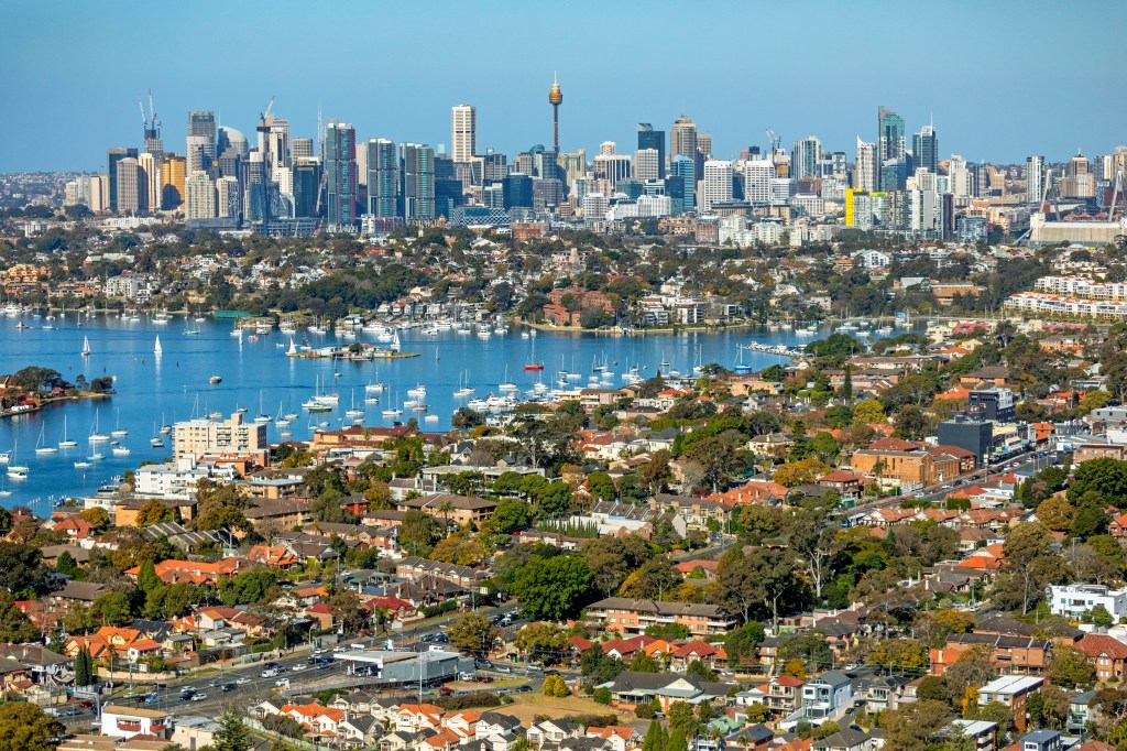 Aerial view across suburb of Drummoyne with Victoria Road, Parramatta River and east toward Sydney city on the horizon. 