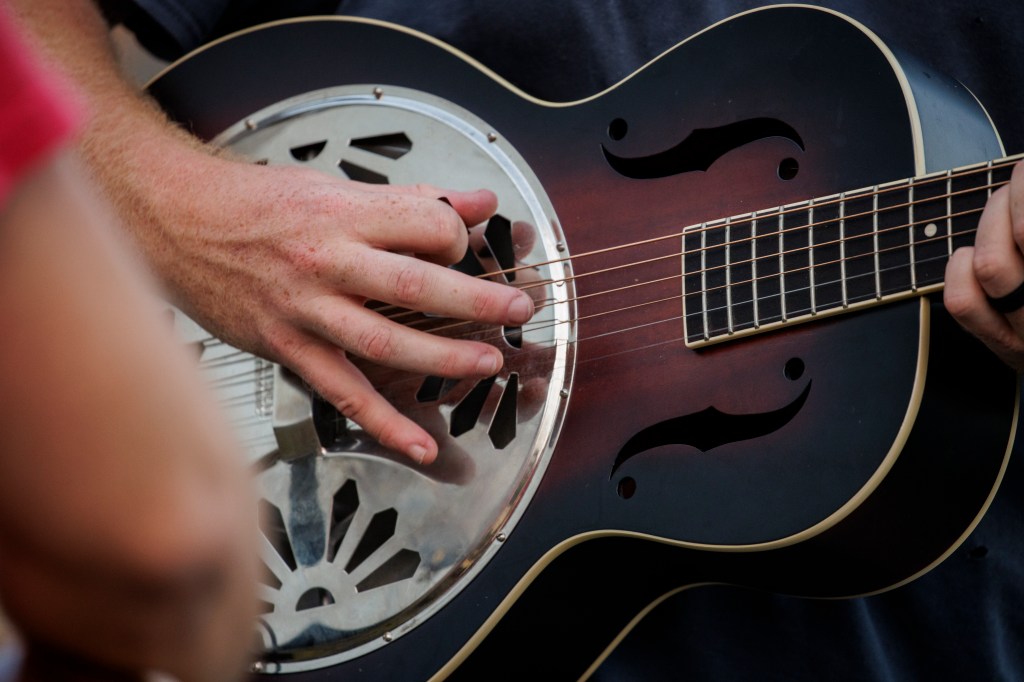 FARMVILLE, VIRGINIA - AUGUST 26: Christopher Anthony Lunsford, who goes by the stage name Oliver Anthony, warms up on his Gretsch G9220 Bobtail Round Neck Resonator next to a loading dock behind the buildings lining Main Street before a surprise performance at the Rock the Block street festival on August 26, 2023 in Farmville, Virginia. Anthony's song "Rich Men North of Richmond" gained notoriety after it was played at the recent Republican presidential primary debate. (Photo by Samuel Corum/Getty Images)