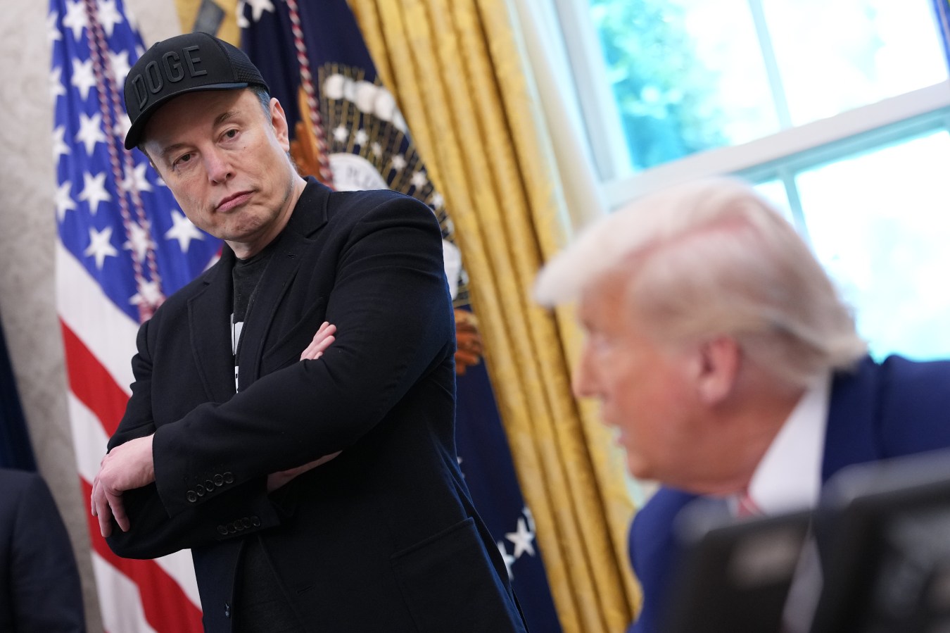 WASHINGTON, DC - MAY 30: Tesla CEO Elon Musk listens as U.S. President Donald Trump speaks to reporters in the Oval Office of the White House on May 30, 2025 in Washington, DC. Musk, who served as an adviser to Trump and led the Department of Government Efficiency, announced he would leave his role the Trump administration to refocus on his businesses. (Photo by Kevin Dietsch/Getty Images)