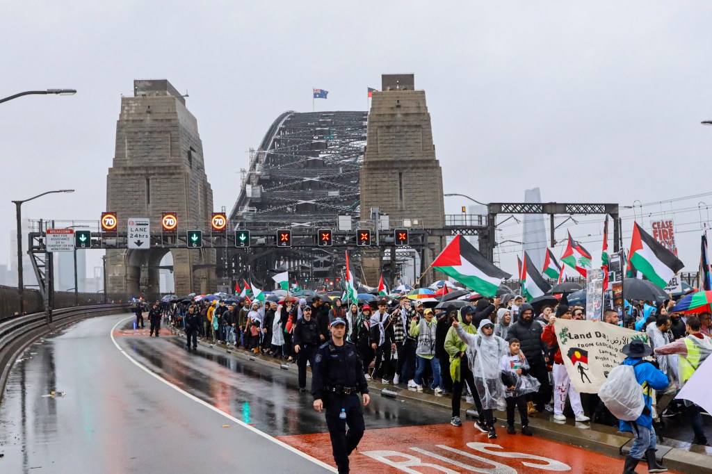 SYDNEY, AUSTRALIA - 2025/08/03: Protesters march across the Sydney Harbour Bridge during the rally. Thousands of protesters took part in the "March for Humanity Save Gaza," crossing the Sydney Harbour Bridge to call for an end to Israel's military assault on Gaza and demand immediate humanitarian aid access. The march was part of a broader movement across Australia condemning the bombardment, displacement, and civilian deaths in the besieged territory. Protesters also raised urgent concerns over the deepening food crisis, with the United Nations warning that more than a million Palestinians in Gaza are facing catastrophic hunger, particularly children suffering from severe malnutrition. (Photo by Ye Myo Khant/SOPA Images/LightRocket via Getty Images)